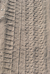 Traces of car tires on a sandy road. Background image on the theme of roads and travel
