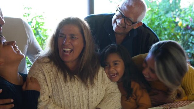 Hapy latin family having fun together in front of camera at house terrace - Grandparents, parents and children
