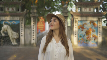 Portrait of Asian Vietnamese woman travel in The Red Bridge in public park garden with trees in Hoan Kiem Lake in Downtown Hanoi. Urban city, Vietnam..
