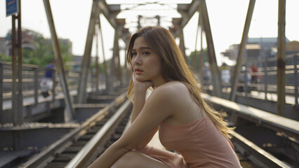 Portrait of Asian Vietnamese fashion woman. Vintage steel train bridge at Long Bien railway through a river in Downtown Hanoi, Vietnam. Urban city town. People lifestyle.