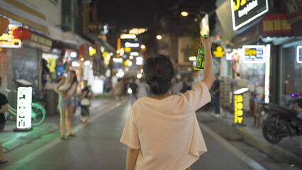 Drunk alcoholic woman Asian Vietnamese woman travel at night, drinking beer in market. People...