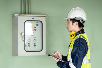 Building inspector man using digital tablet checking air pressurized fan system cabinet. Asian male...