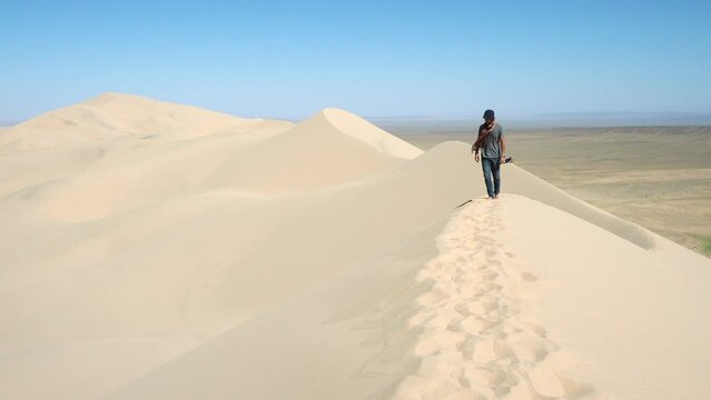 Traveller exploring the famous Khongoryn Els sand dunes in the Gobi Desert of Mongolia. 