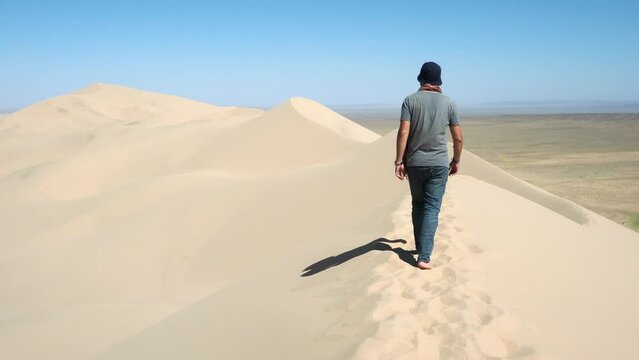 Tourist exploring the famous Khongoryn Els sand dunes in the Gobi Desert of Mongolia. 