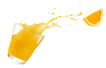 Tilted drinking glass with orange juice spilling out and a flying orange slice isolated on white...