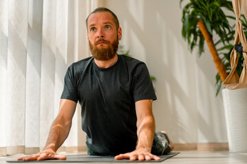 adult man with a beard doing stretching and back health lying on the floor sport active lifestyle