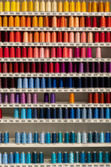 Multi-colored spools of thread on the shelf
