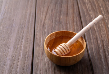 Honey in a tiny bowl with wooden dipper and copy space