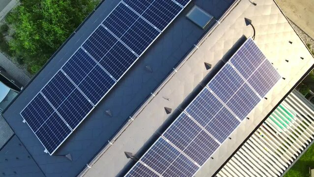 Aerial view to new modern solar panels on the roof of a luxury house, alternative energy source for home, green energy from the sun, industrial concept
