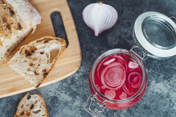 Fototapeta na wymiar Pickled rings red onions with slices of homemade bread. Healthy organic food. top view 