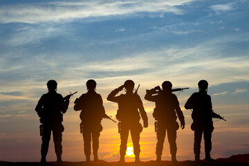 Fototapeta na wymiar Military silhouettes of a soldiers against the sunset. Concept - Armed Force