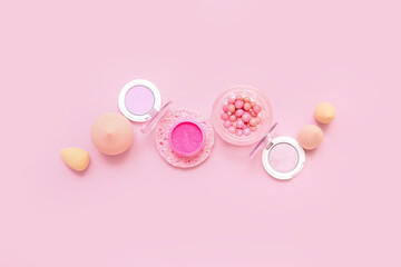Decorative cosmetics with makeup sponges on pink background