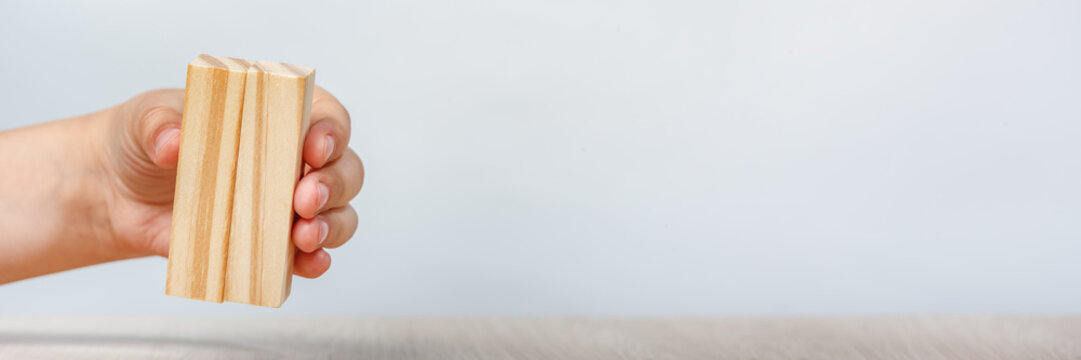 Wooden rectangles in hand. Wooden rectangle in hand with copy space on a gray background.