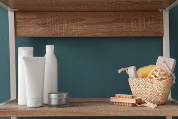 Fototapeta na wymiar Shelving unit with bath accessories near blue wall, closeup