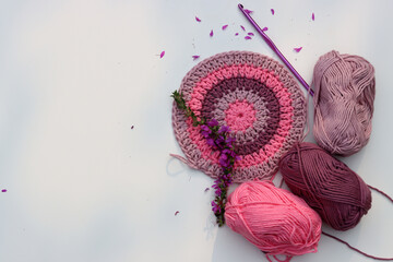 Crocheted round element top view. Organic pink cotton yarn on white background with copy space....