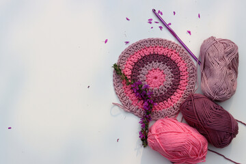 Crocheted round element top view. Organic pink cotton yarn on white background with copy space....