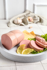 Plate with tasty boiled sausage on table