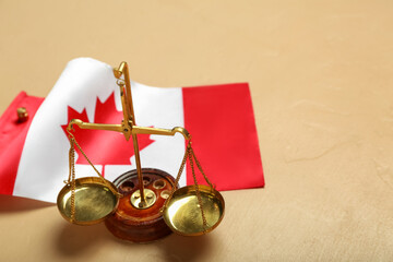 Flag of Canada with justice scales on beige background, closeup