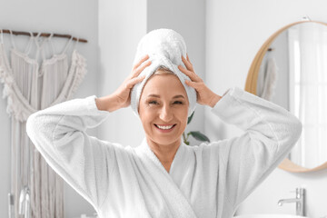 Mature woman with towel in bathroom
