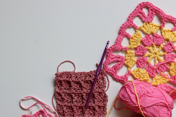 Different crocheted elements on white background with copy space. Handmade home decoration....