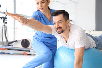 Obraz premium Female physiotherapist working with young man in rehabilitation center