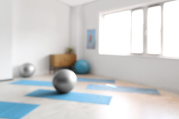 Blurred view of rehabilitation center with fitballs and mats