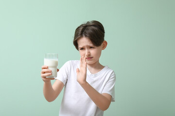 Little boy with lactose intolerance on turquoise background