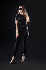 Beautiful young woman with stylish sunglasses on black background