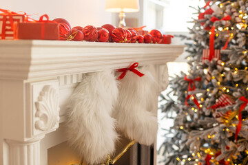 Obraz premium Christmas Tree and Christmas gift boxes in the interior with a fireplace.