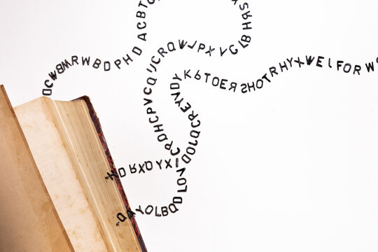 Open book with falling black letters, the concept of grammar and , foreign language, creativity and ideas for a story