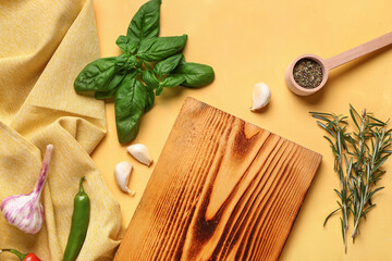Fototapeta na wymiar Composition with wooden cutting board, fresh spices and herbs on color background