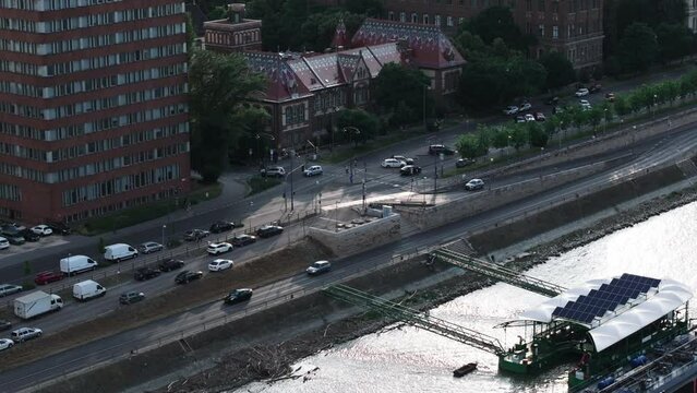 Aerial slide and pan footage of beautiful historic building with colour roof. Complex of BME university buildings at Danube riverbank. Budapest, Hungary