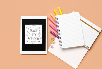 Card with text BACK TO SCHOOL, tablet and different stationery on brown background