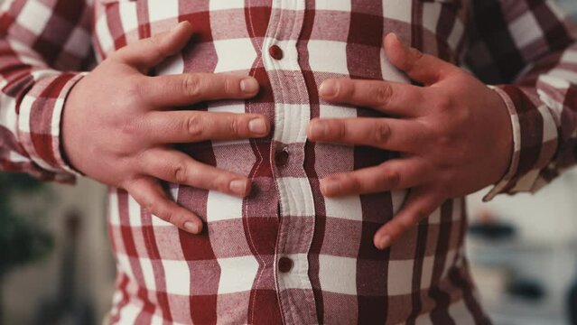 Closeup of obese man petting his belly, weight gain, health problems, overeating