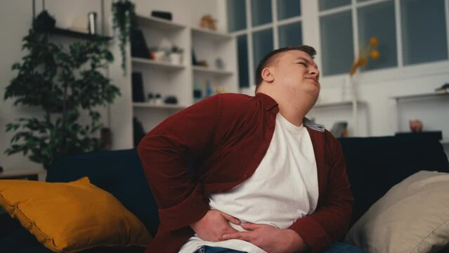Young overweight man suffering from liver pain, feeling stomach ache, problem