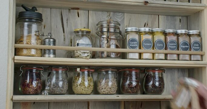 Placing spices on custom built wooden spice rack
