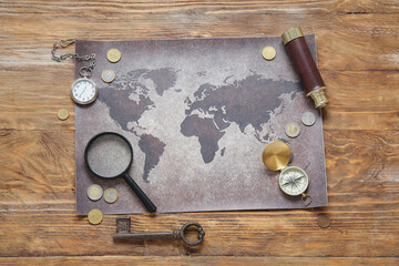 World map with different pirate equipment on brown wooden background