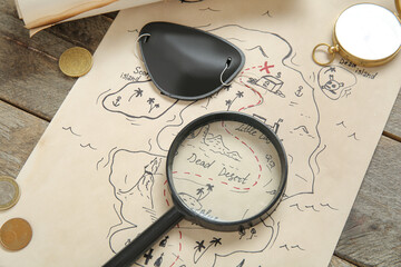 Treasure map with pirate eye patch, magnifier and coins on brown wooden background