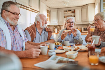 Group of senior friends having breakfast in the morning in the kitchen