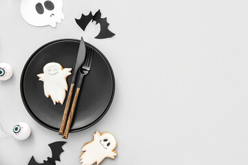 Halloween table setting with eyes and tasty cookies on light background
