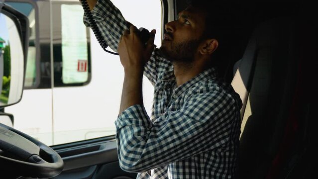 Indian Man Talking on CB Radio. Truck Driver Job. Trucker Preparing For Trip. Right Hand Drive Car