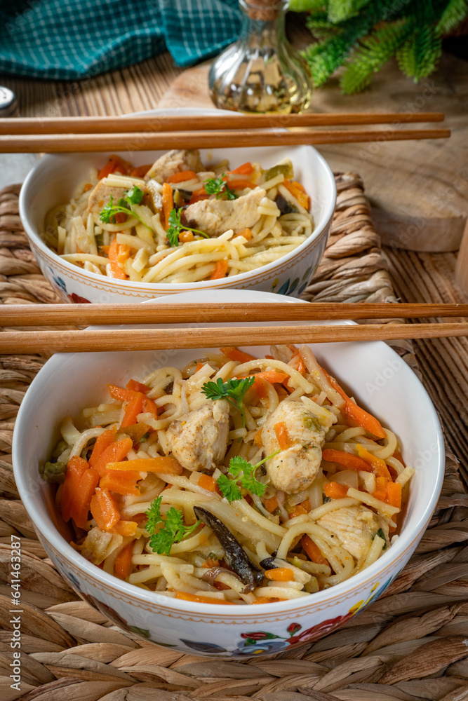 Poster fried noodles with chicken and vegetables.