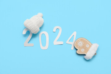 Figure 2024 made of paper and Christmas decorations on blue background