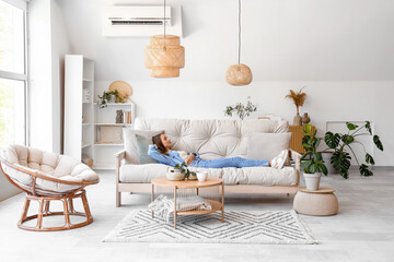 Young woman lying on couch in living room