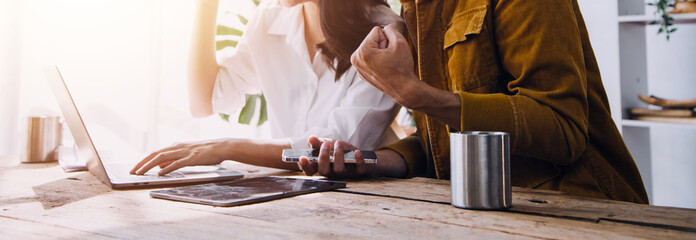 Entrepreneur Asian businessman and businesswoman discussing new business project in tablet in modern Meeting In Modern Office, Asian business casual concept.