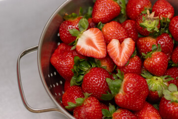 Closeup bowl full of strawberries, strawberry heart, valentines day. Background 
