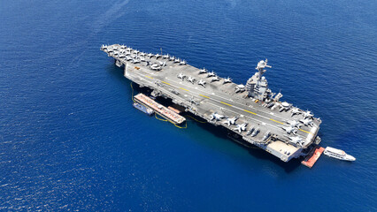 Aerial drone photo of latest technology nuclear powered aircraft carrier anchored in deep blue open ocean sea
