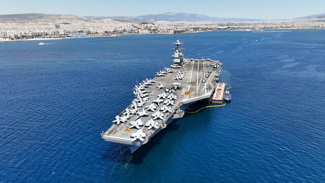 Aerial drone photo of latest technology American flag nuclear aircraft carrier anchored in deep blue sea