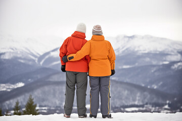 Fototapeta na wymiar Senior couple admiring view on the winter mountains. Generative AI