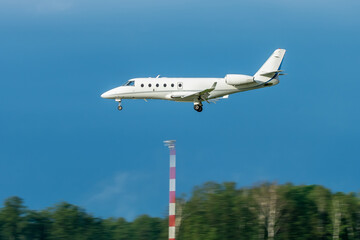 A private white small business jet comes in for a landing. Jet corporate business aviation....
